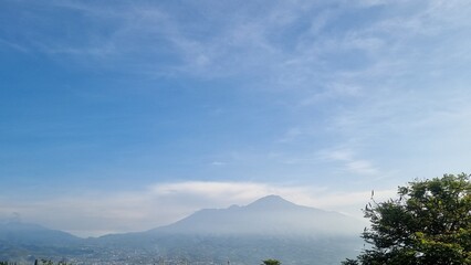 Scenic view of Mount Arjuno Welirang in Batu, Indonesia. The second highest mountain in East Java. Scenic mountain landscape with soft morning mist and colorful sky. Beautiful nature view. For travel 