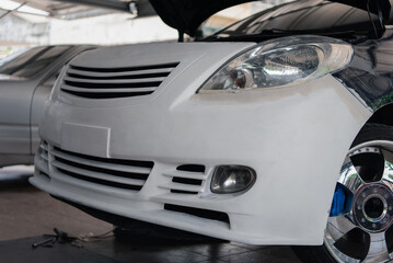 Denter or car mechanic serviceman check and fix body work and fiber bumper body part for fix and repair problem at car garage or repair shop