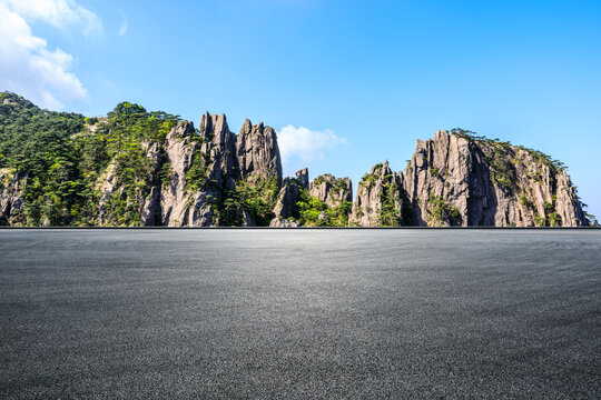 Empty asphalt platform and rocky mountain with green trees under blue sky in Huangshan, Anhui, China. - Powered by Adobe