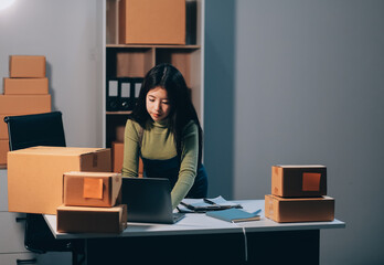 Startup SME small business entrepreneur of freelance Asian woman wearing apron using laptop and box...