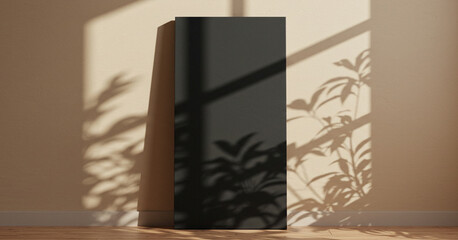 Black rectangular object stands on a wooden floor with plant shadows on the wall.