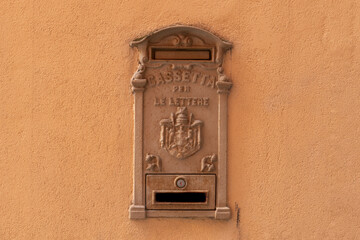 Italian mailbox (cassetta per lettere) on yellow concrete wall