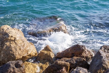 Coastal foamy waves crashing on the rocks on the Athens promenade