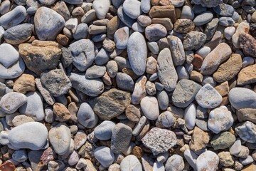 Top view of natural pebble stones on the shore of a Mediterranean beach. Nature background for design
