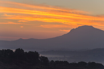 Serene landscape at dawn with mist and fog in Bhandardara, Maharashtra, India. Soft focus