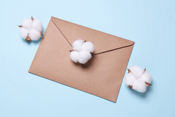 Kraft envelope and cotton flowers on beige background.