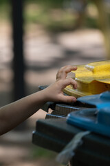 Childs Hand Near Recycling Bins in Park Vertical Photo