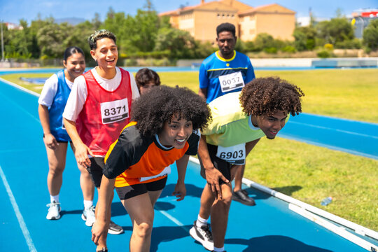 Athletes getting ready for a race on a blue track