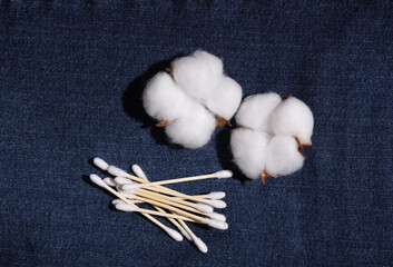 Cotton swabs and flowers on jeans. Personal hygiene