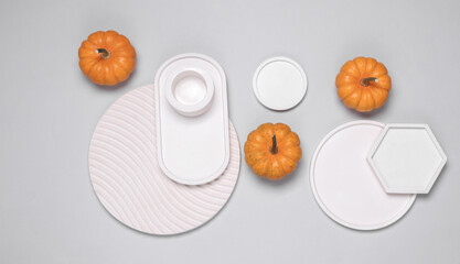 Miniature pumpkins and plaster figures on a gray background. Creative layout