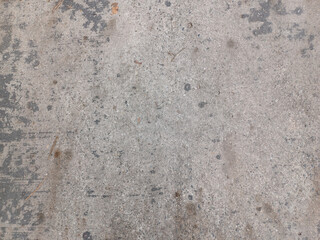 Textured, weathered, mottled gray concrete surface features dark stains, lighter rough patches, small indentations, and subtle tonal variations, all contributing to a distressed and rustic aesthetic