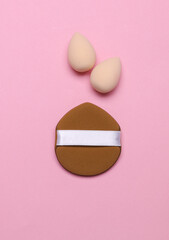 Makeup sponges on pink background. Top view