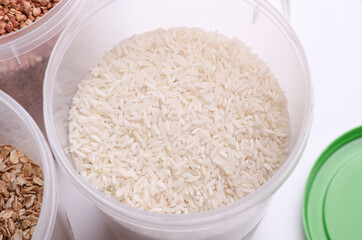 Plastic jars with buckwheat, oatmea and rice on white background. Top view