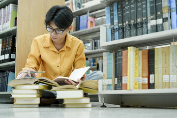 Student Of University Choosing Book and Reading Book In Library.