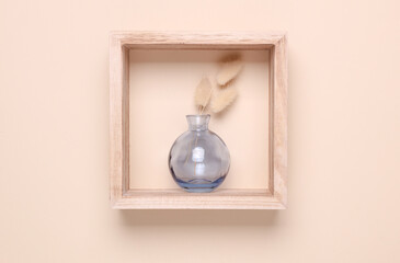 Glass vase with dried flowers in wooden square shelves on beige background. Minimalistic aesthetic...