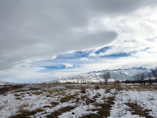 Snow covered mountains in Kyrgyzstan under cloudy winter sky peaceful rural landscape