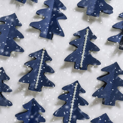 Trend square pattern from blue Christmas trees cut out of craft paper, happy holidays concept. Diy blue tree firs decorated snowflakes and pearls. Minimal greetings card, Creative top view