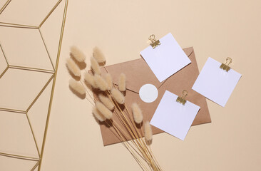 Mood board and envelope with square cards and dried lagurus flowers on beige background. Aesthetic...