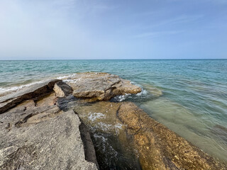 Rocky shore and clear water of Issyk-Kul under a vast sky