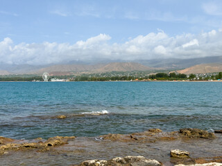 Rocky shore and clear water of Issyk-Kul under a vast sky