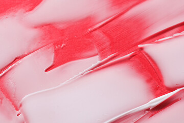 Shape and texture of white cream strokes on red background. Beauty concept
