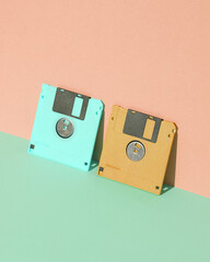 Pink and blue Floppy disks on pastel background. Retro 80s. Outdated technology. Creative layout,...