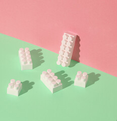 Toy bricks constructor on pink green background. Creative layout