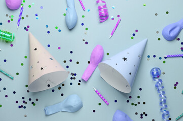 Birthday cone caps, confetti, candle and balloons on pastel background. Party concept. Top view