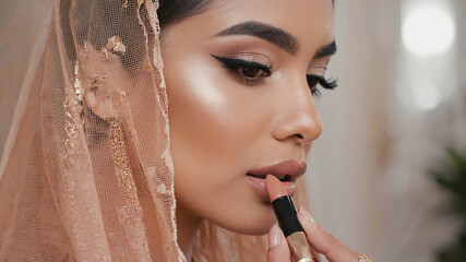 Elegant Woman Applying Nude Lipstick with Peach Veil Emphasizing Bridal Makeup Look. Image made using Generative AI.