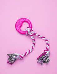 Dog rubber toy with rope on pink background