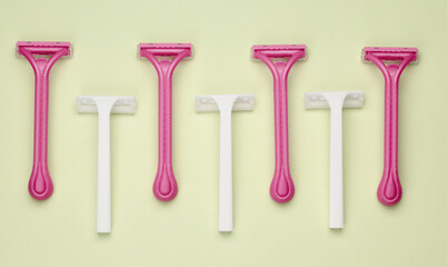 Disposable plastic razors on green background. beauty concept. Top view. Creative layout
