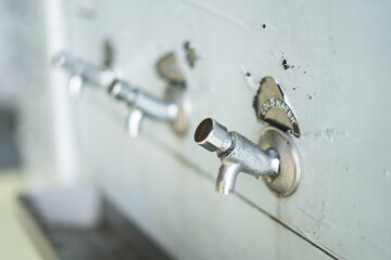 cold water taps on an old public drinking water dispenser 