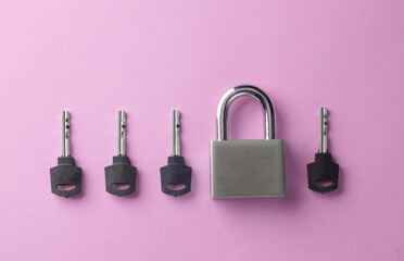 Closed metal lock with keys on a pink background