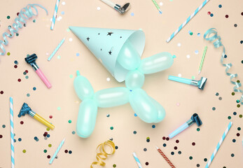 Dog shaped balloon and birthday accessories on pink background