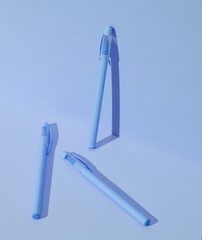 Plastic pens on blue background. Business, education concept. Creative layout, minimalism. Modern art