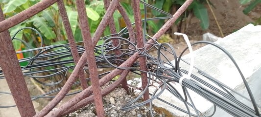 Coiled Fiber Cable Wrapped Around Rusty Metal Rod, Close-Up of Industrial Wiring and Corroded Iron Surface, Contrast of Modern Technology and Aged Infrastructure