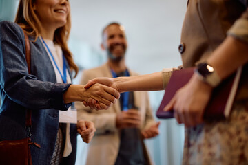 Close up of businesswomen shaking hands in office.