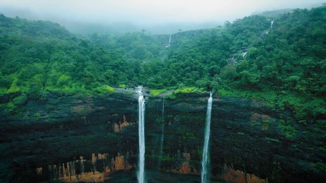 4K Aerial shot of Kataldhar waterfall flowing in Sahyadri forest and falling in valley at Lonavala, Maharashtra, India. Greenery in Sahyadri hills during monsoon season. Nature, heaven background