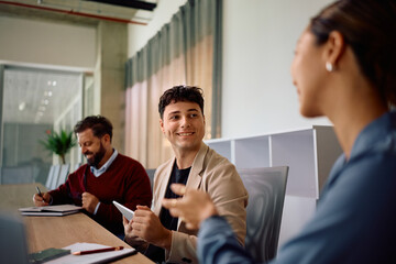 Happy businessman talking to colleague on meeting in office.