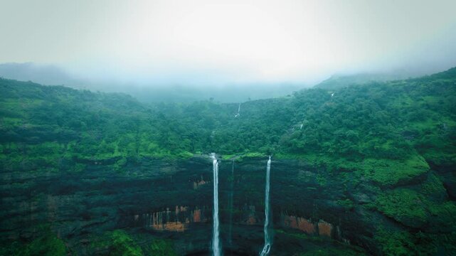 4K aerial shot of Kataldhar waterfall flowing from Sahyadri hills in Maharashtra, India. Monsoon background. Lush green landscape.