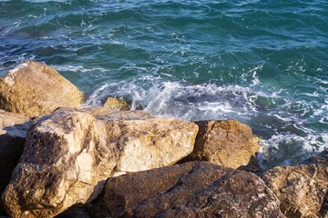 Coastal foamy waves crashing on the rocks on the Athens promenade