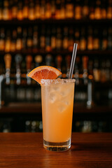 Fresh Grapefruit Cocktail Served on Wooden Bar with Ice and Slice Garnish
