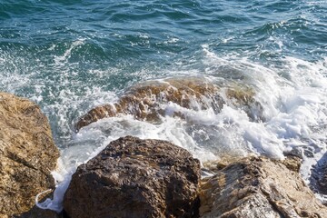 Coastal foamy waves crashing on the rocks on the Athens promenade