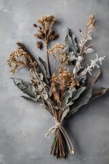 Still life of winter's bouquet with faded charm and quiet beauty on a textured grey backdrop, perfect for serene reflection