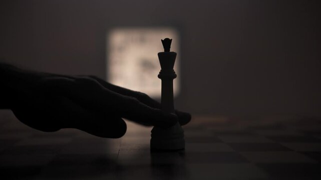 Man hand moves the queen backward with a short move on chessboard, make its move