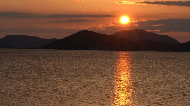 sun going down behind the mountain and evening sea.  x4 Without sounds