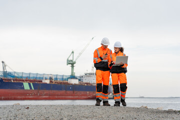 Industrial Engineers Collaborating at Harbor Site, Dock Worker in Safety Uniforms Using Technology...