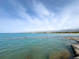 Rocky shore and clear water of Issyk-Kul under a vast sky