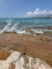 Rocky shore and clear water of Issyk-Kul under a vast sky
