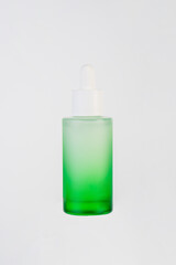 Green glass cosmetic bottle, Skin care or sunscreen cosmetic on white background.